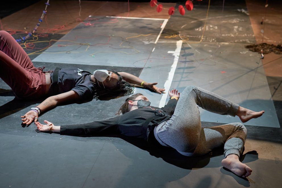 Two dancers in mask lying on the floor