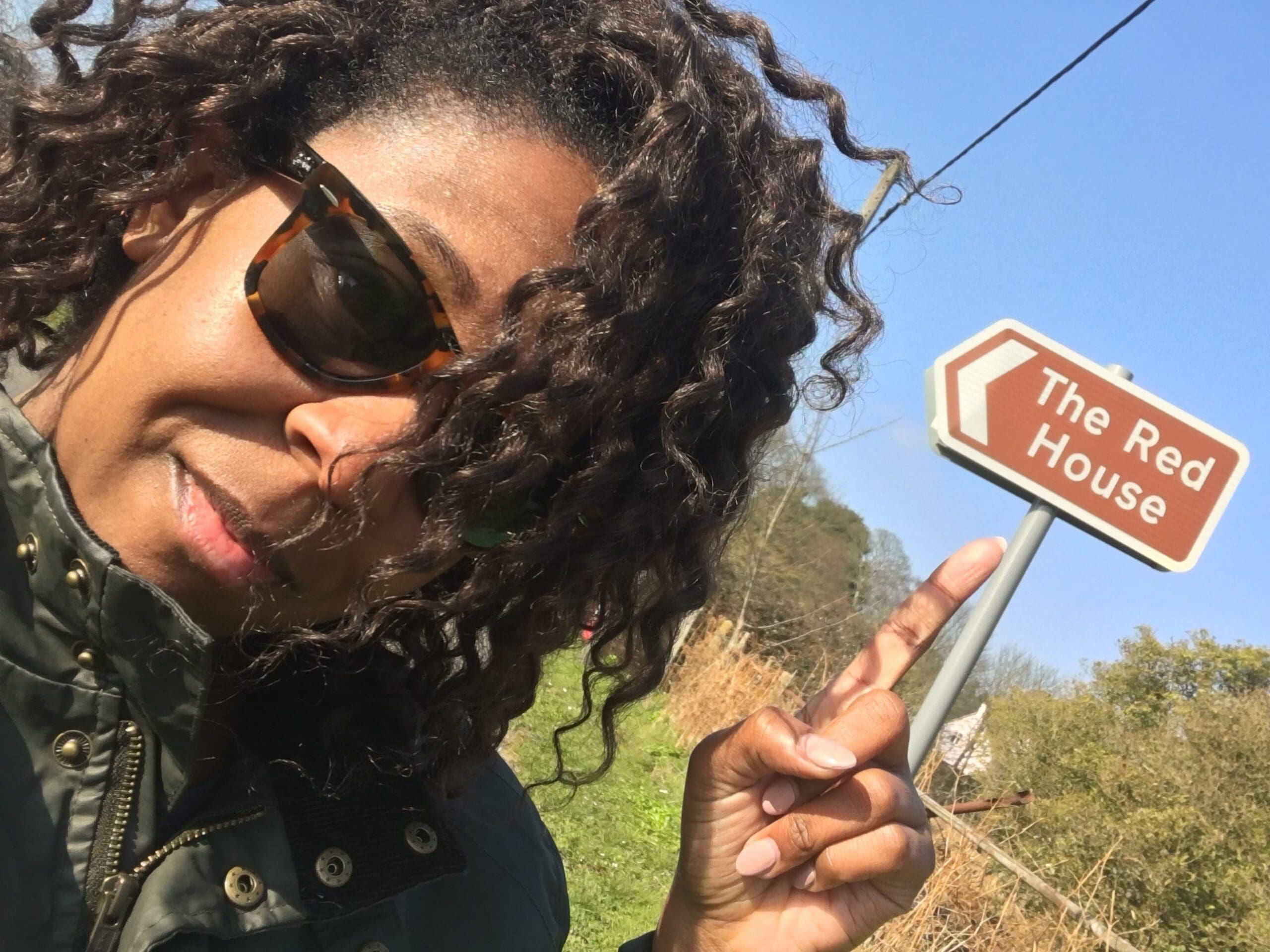 Imani pointing to a road sign for the Red House