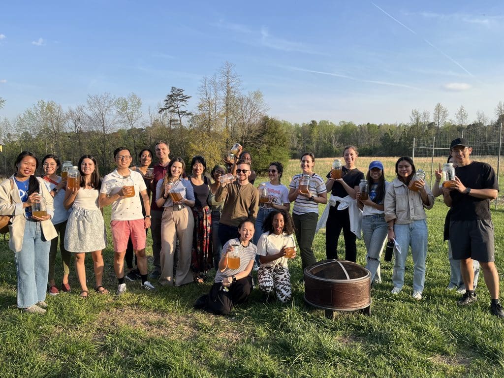 Participants of the workshop showing off their jars of kombucha as a group at Duke Campus Farm.