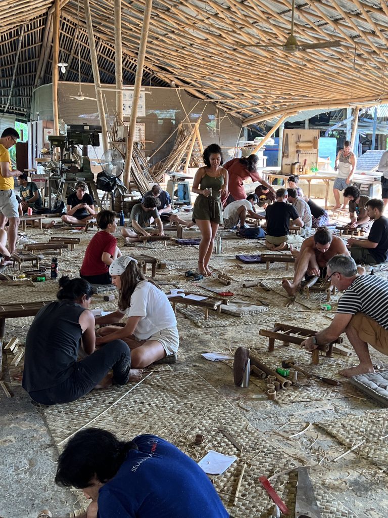 People building with bamboo below a canopy of bamboo