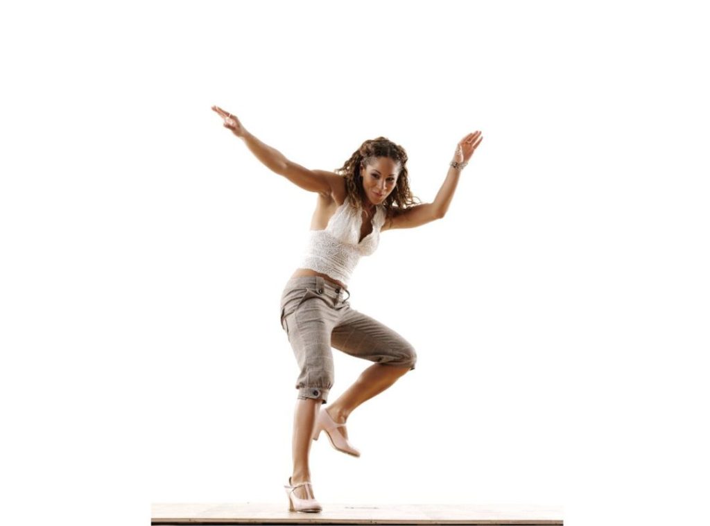 tap dancer with white shirt, gray pants, and white shoes on white background