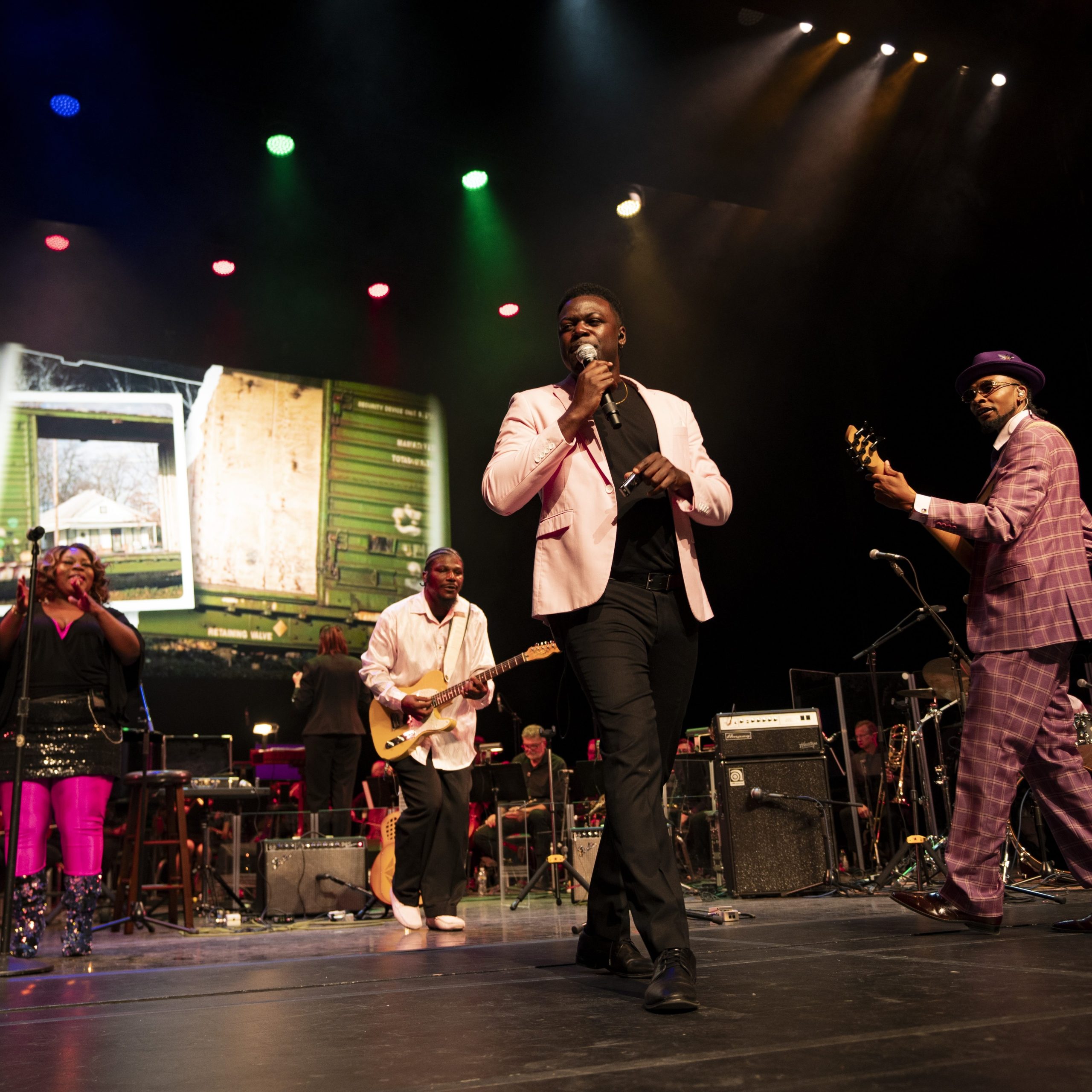 Four performers and musicians sing on stage