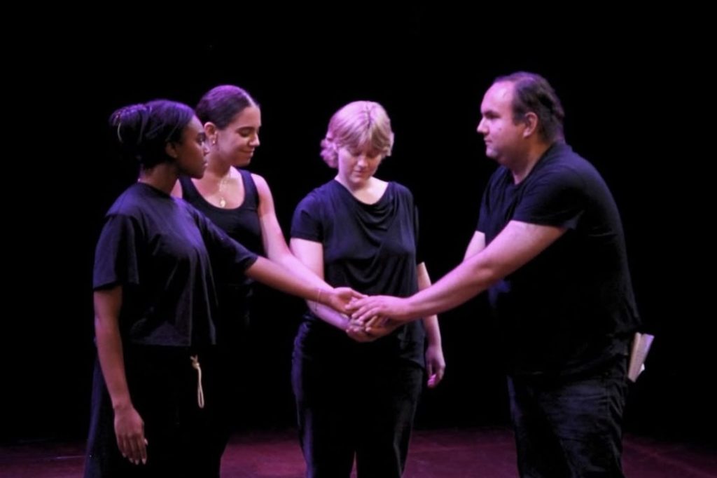 People coming together on a dark stage 